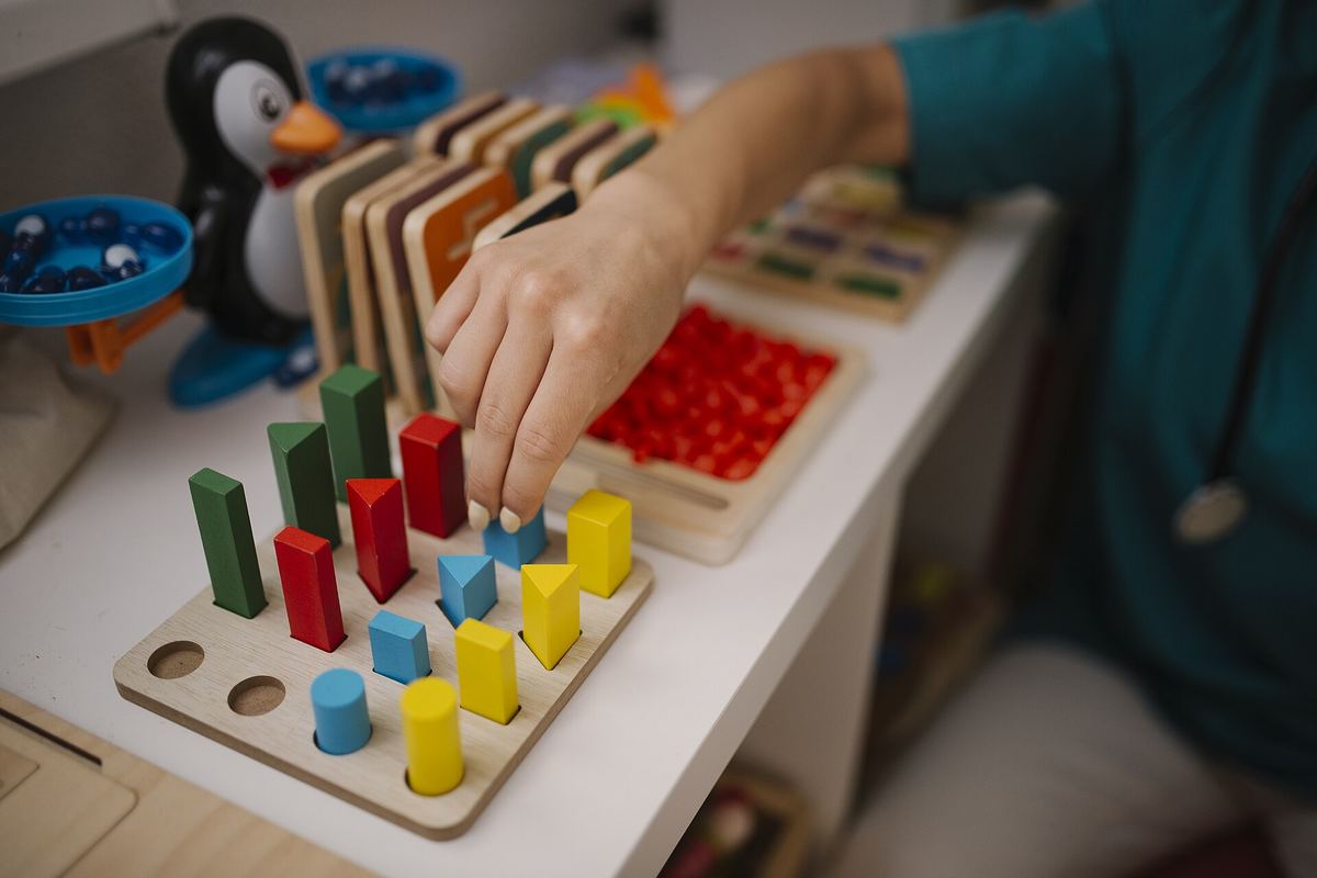 A child sorting coloured wooden blocks by height on a board